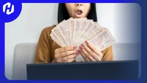 wanita sedang memegang uang baht yang disimpan untuk masa depan