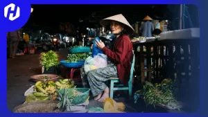 seorang nenek sedang berjualan di malam hari karena pasarnya baru buka di saat malam